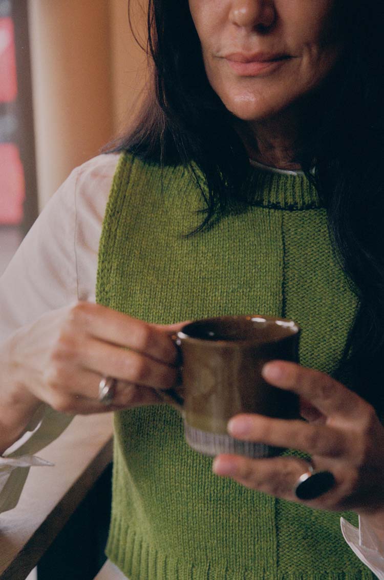 Ada Sweater Vest in moss green lambswool, layered over a white shirt — sustainable British knitwear made in London by Saywood