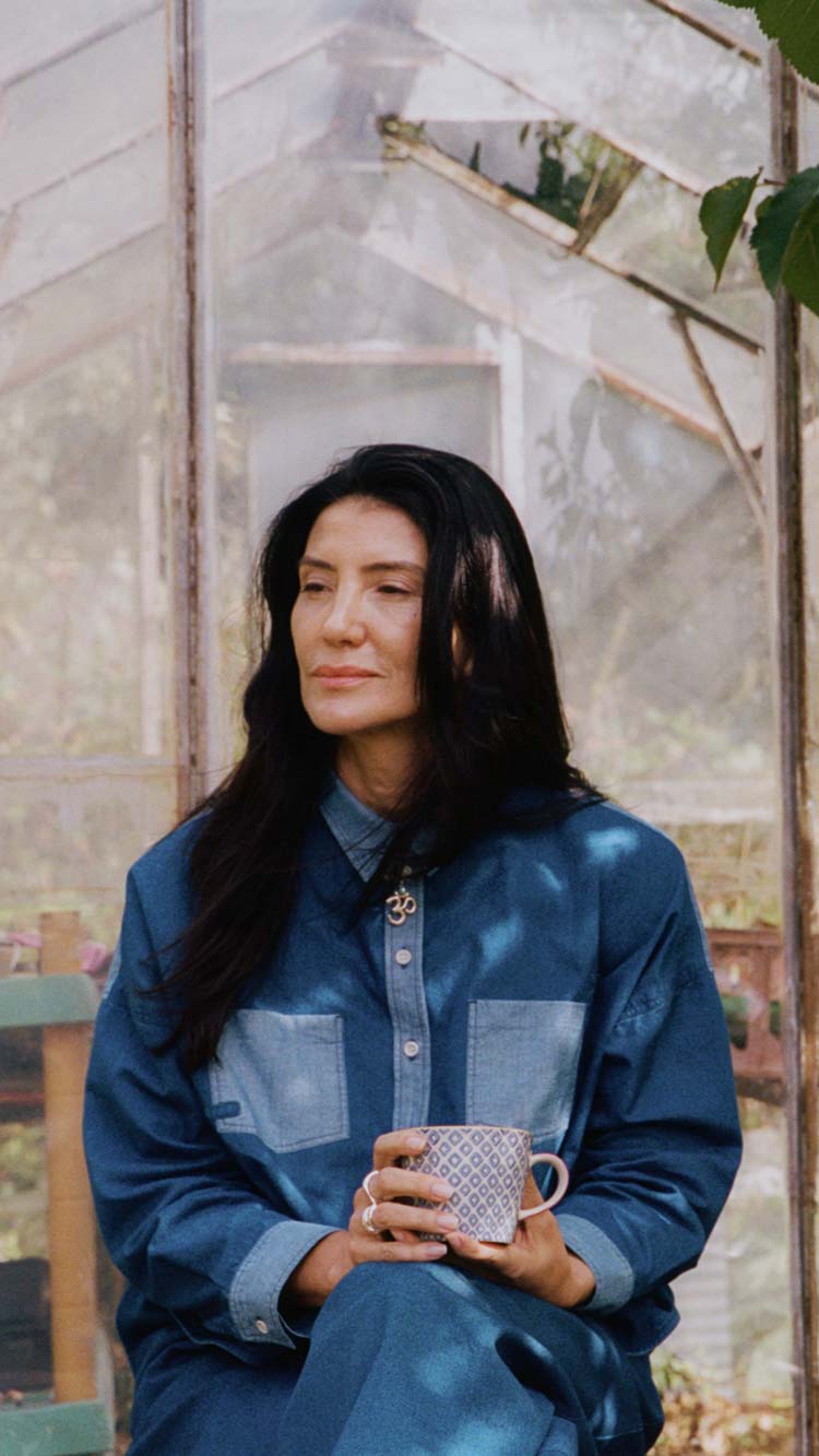 Lela Shirt in Japanese indigo denim, worn relaxed in a sunlit garden setting — made in the UK by Saywood