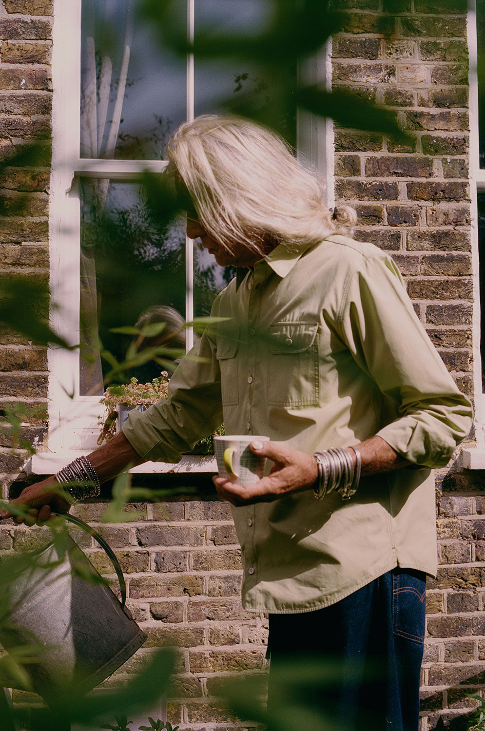 Eddy men's limited edition utility shirt in khaki cotton, relaxed fit, handmade in East London by Saywood. Worn with dark indigo jeans.