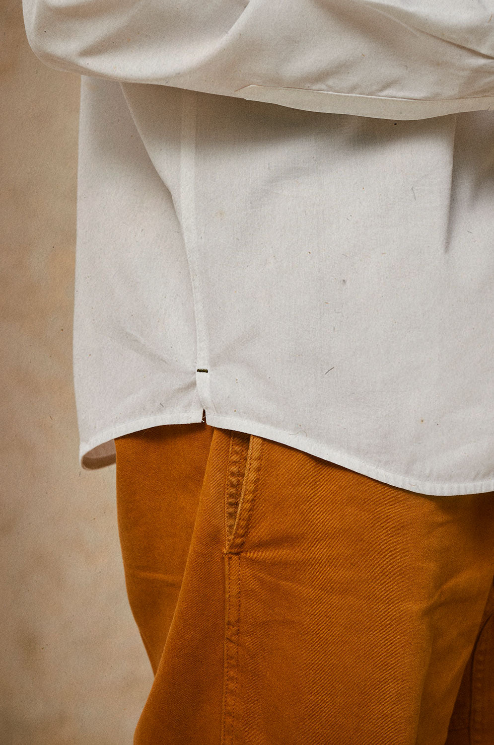Detail view of Eddy classic white shirt showing contrast khaki bar tack at hem side split, cotton bamboo by Saywood