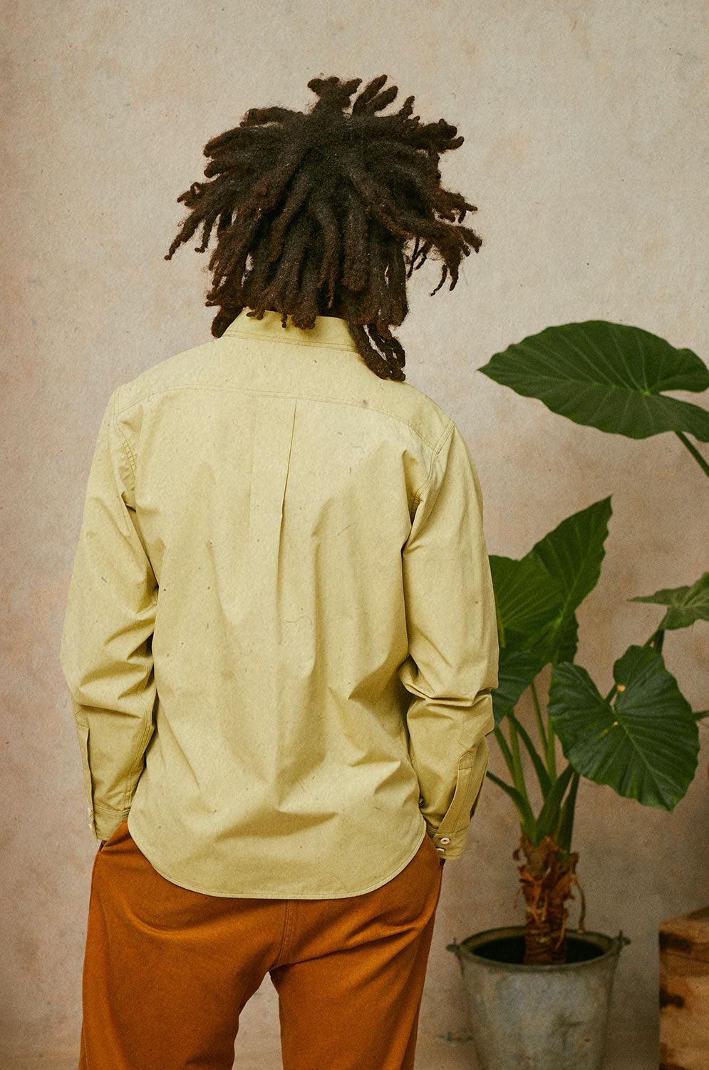 Back detail of Eddy men's khaki utility shirt in heavyweight cotton, relaxed fit, made in East London by Saywood. Worn with tobacco trousers.
