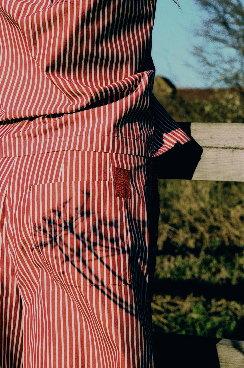 Close-up detail of Bessie shorts back pocket with berry red herringbone tape detail by Saywood