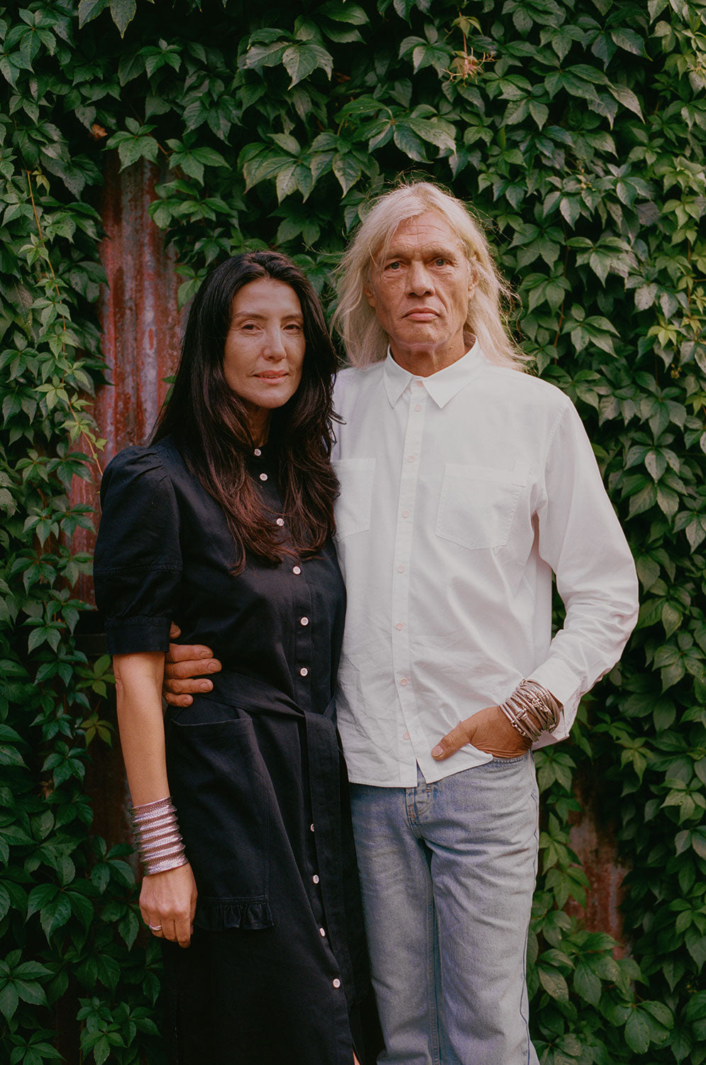 Woman wears Rosa black Japanese denim shirtdress with Eddy men's white patch pocket shirt in cotton bamboo, made in London by Saywood