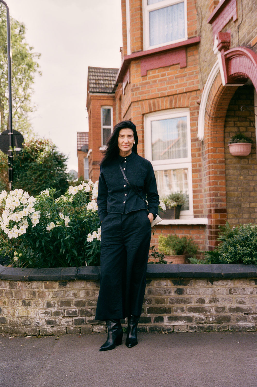 Lela oversized black denim shirt full length, showing relaxed boxy fit, outdoor lifestyle shot. Handcrafted in the UK