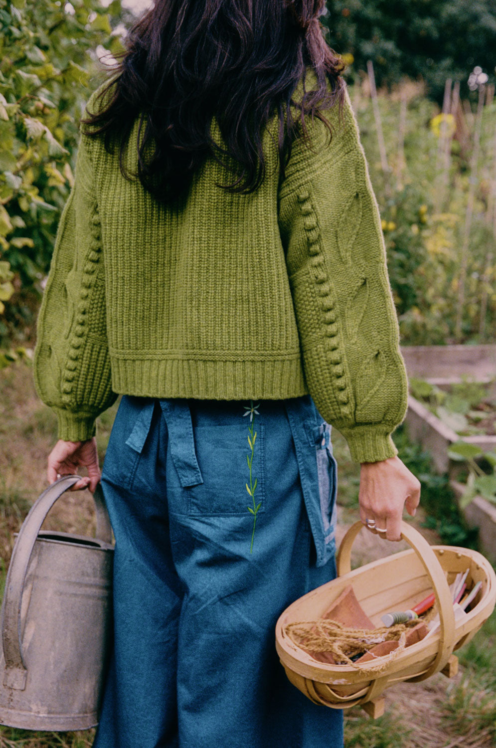 Back view of Amelia Japanese denim trousers with embroidered flower detail, worn with Adams fisherman's rib sweater by Saywood