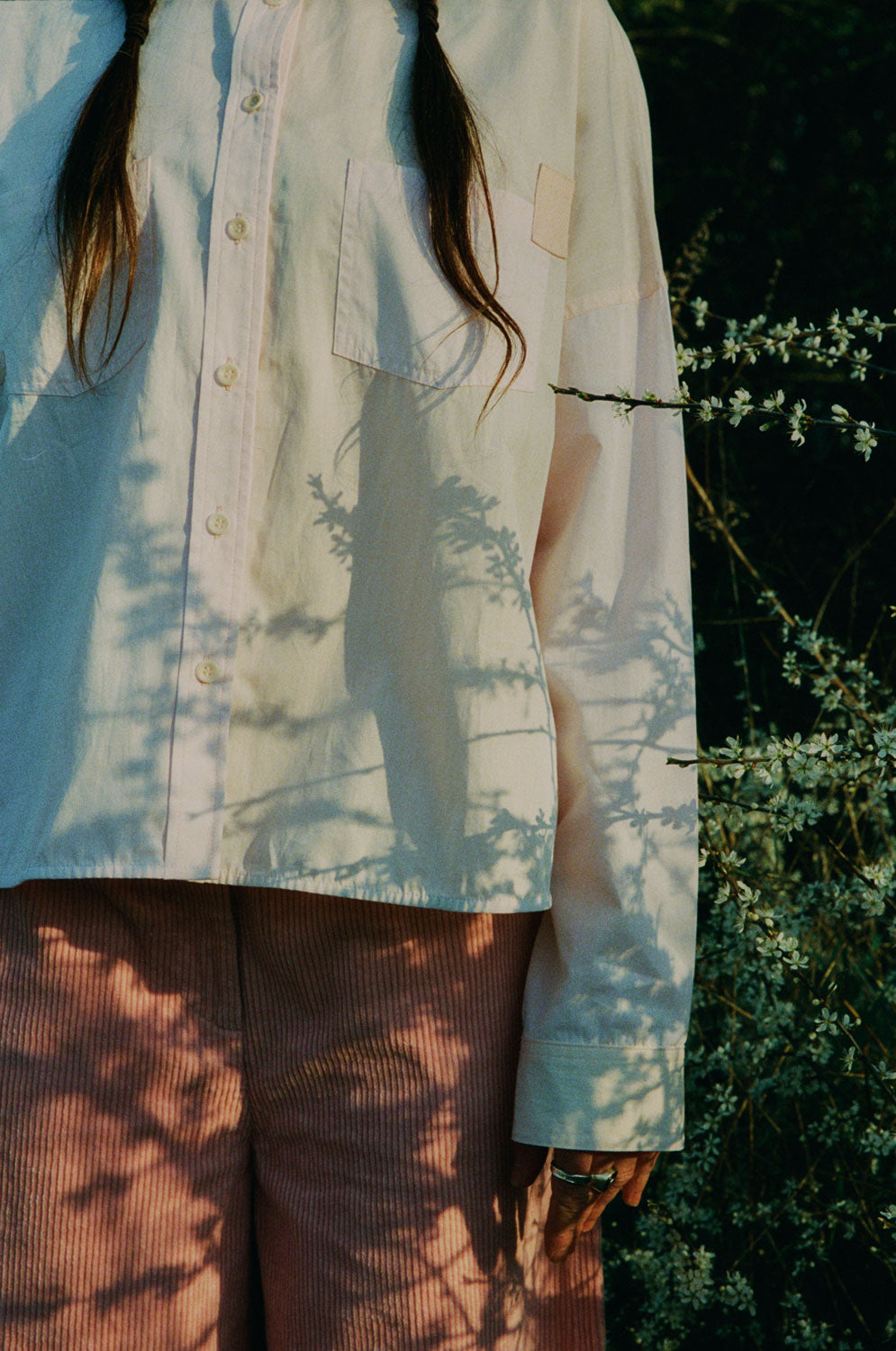 Lifestyle detail: Lela pastel pink orange colourblock boxy shirt with Amelia pink trousers, made in London by Saywood