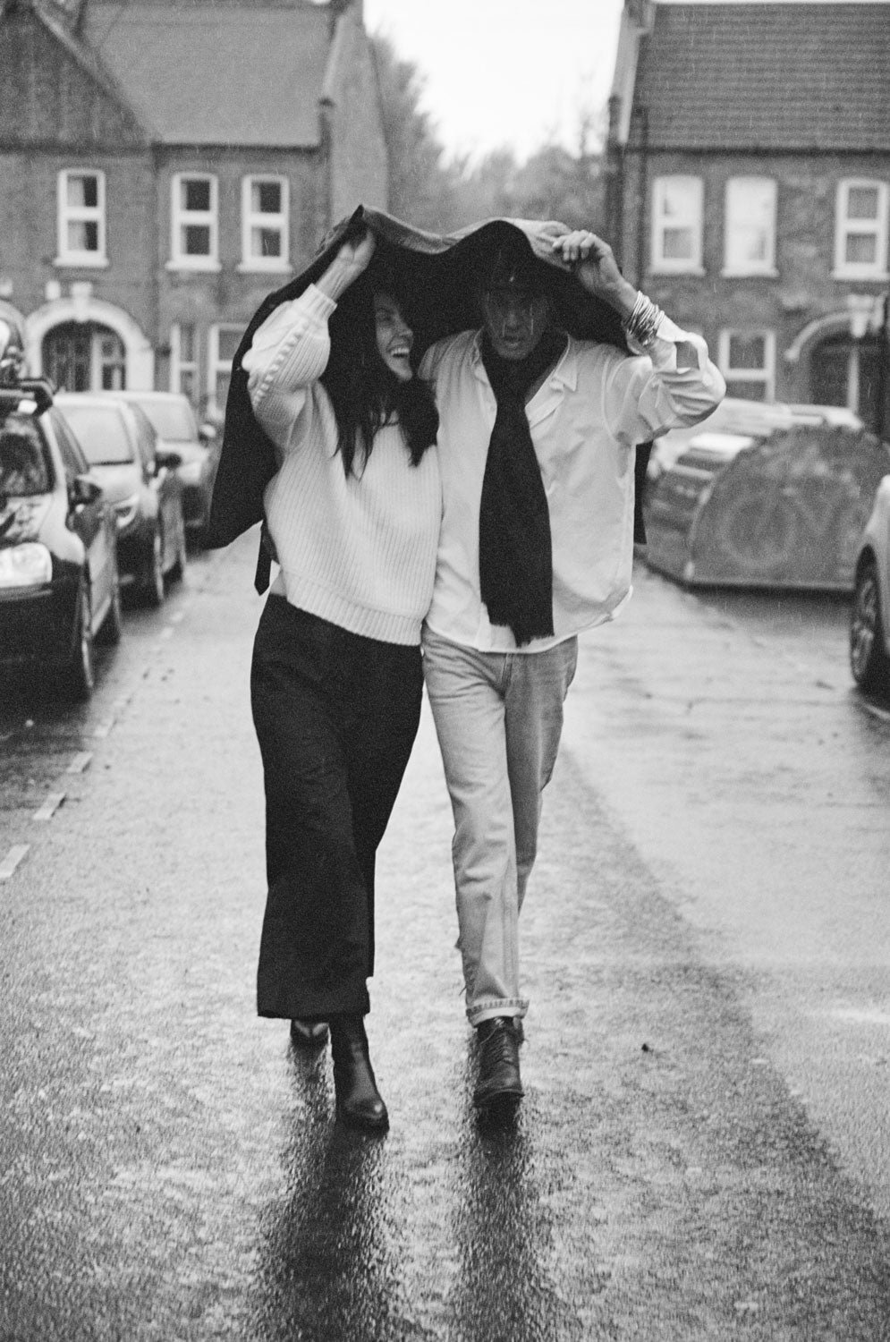 Woman wears Adams cream fisherman rib sweater with Amelia black trousers, man wears Eddy classic white shirt, handmade in London by Saywood