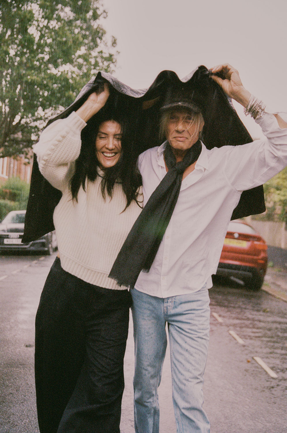 Woman wears Adams cream fisherman rib sweater with Amelia black trousers, man wears Eddy classic white shirt in cotton bamboo, handmade in London by Saywood