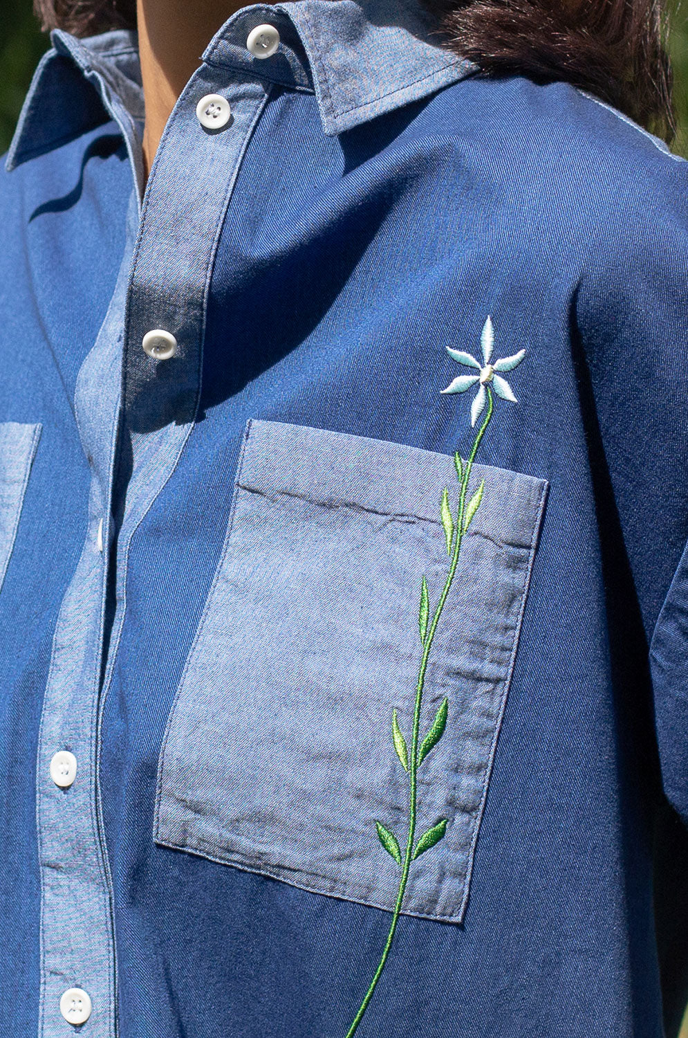 Detail of Etta Japanese denim shirtdress showing embroidered flower and contrast panels