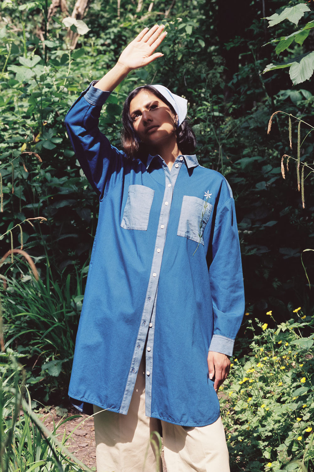 Woman wearing Etta Japanese denim shirtdress over tan trousers with blue bandana