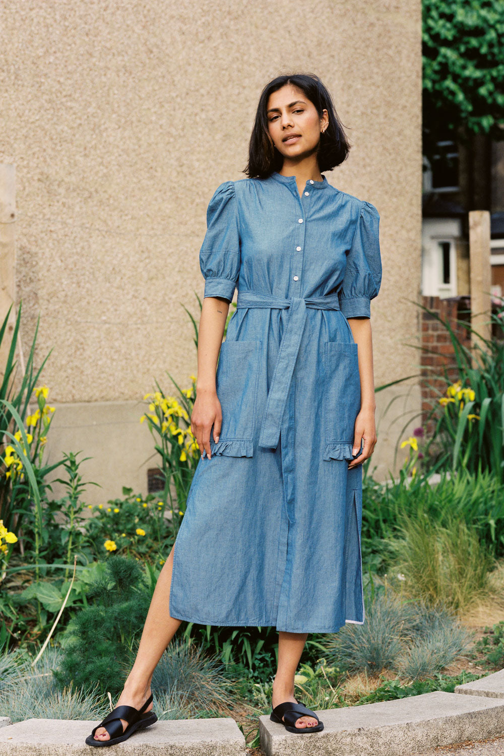 Woman wearing Rosa light wash Japanese denim shirtdress with ruffle pockets and belt