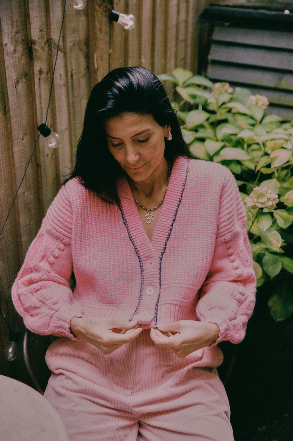 Frida pink lambswool cardigan styled with pink corduroy trousers, outdoor lifestyle shot by Saywood