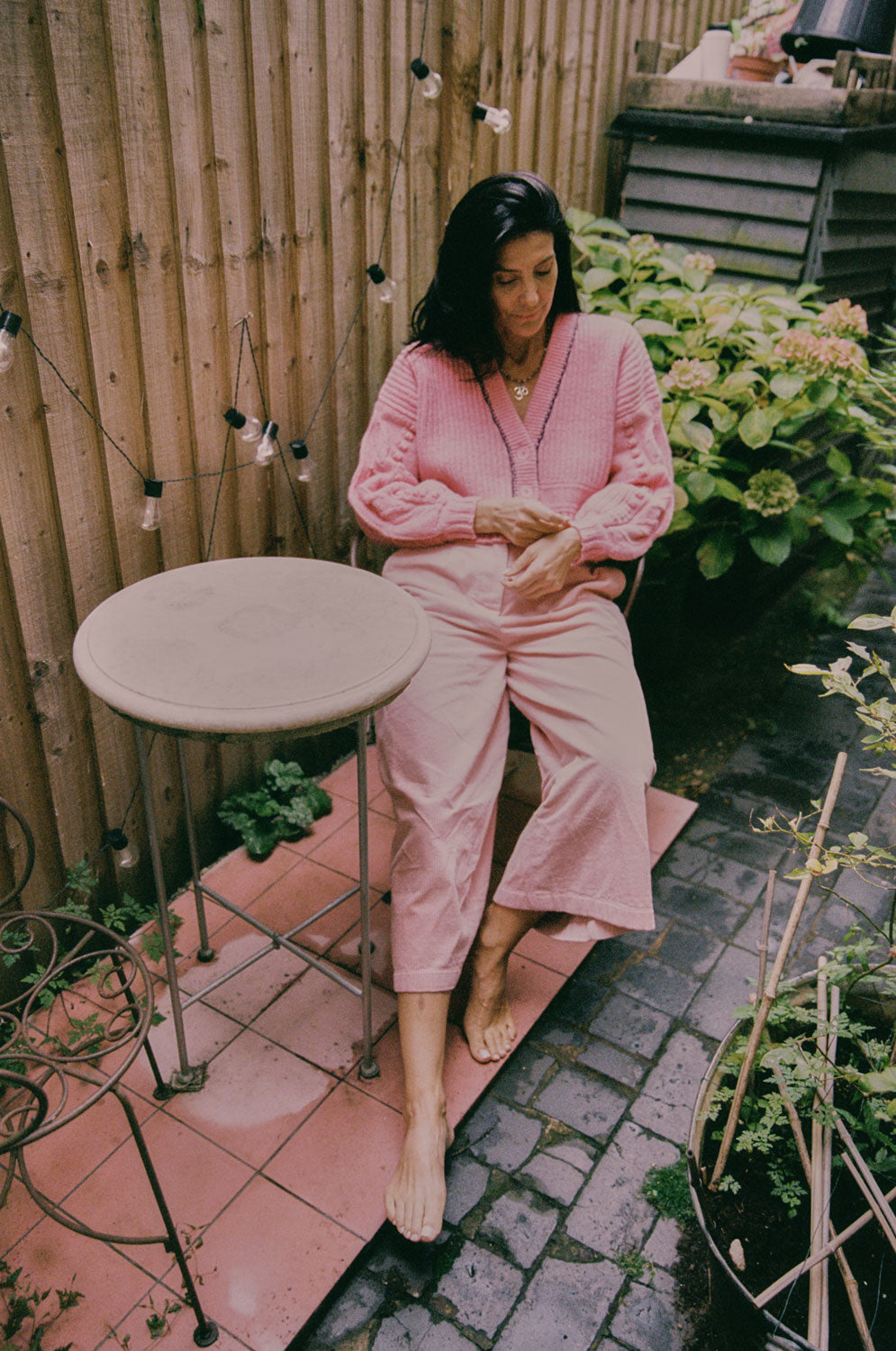 Frida pink cardigan styled with Amelia wide leg trousers, outdoor lifestyle shot, Scottish-spun lambswool