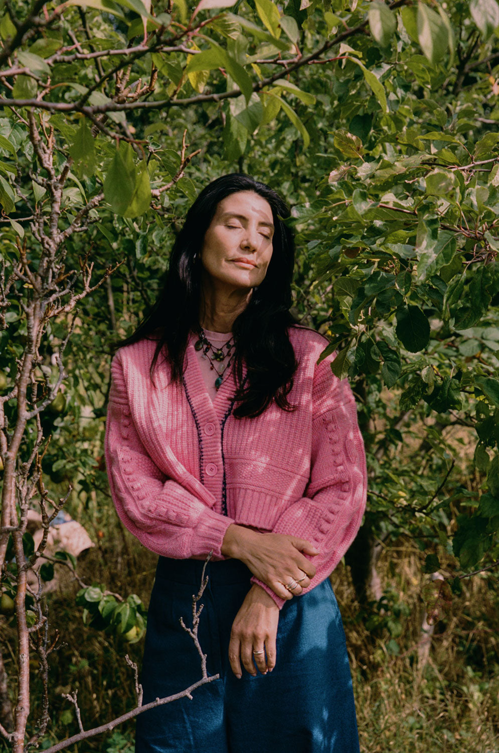 Frida pink chunky knit cardigan full length showing boxy silhouette and balloon sleeves, natural outdoor setting with trees, handcrafted in the UK