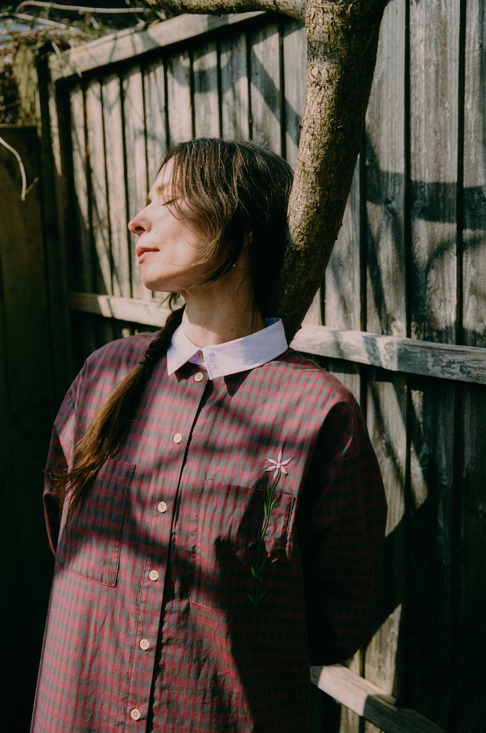 Etta red check shirtdress with lilac collar and embroidered flower pocket detail, outdoor lifestyle shot by Saywood