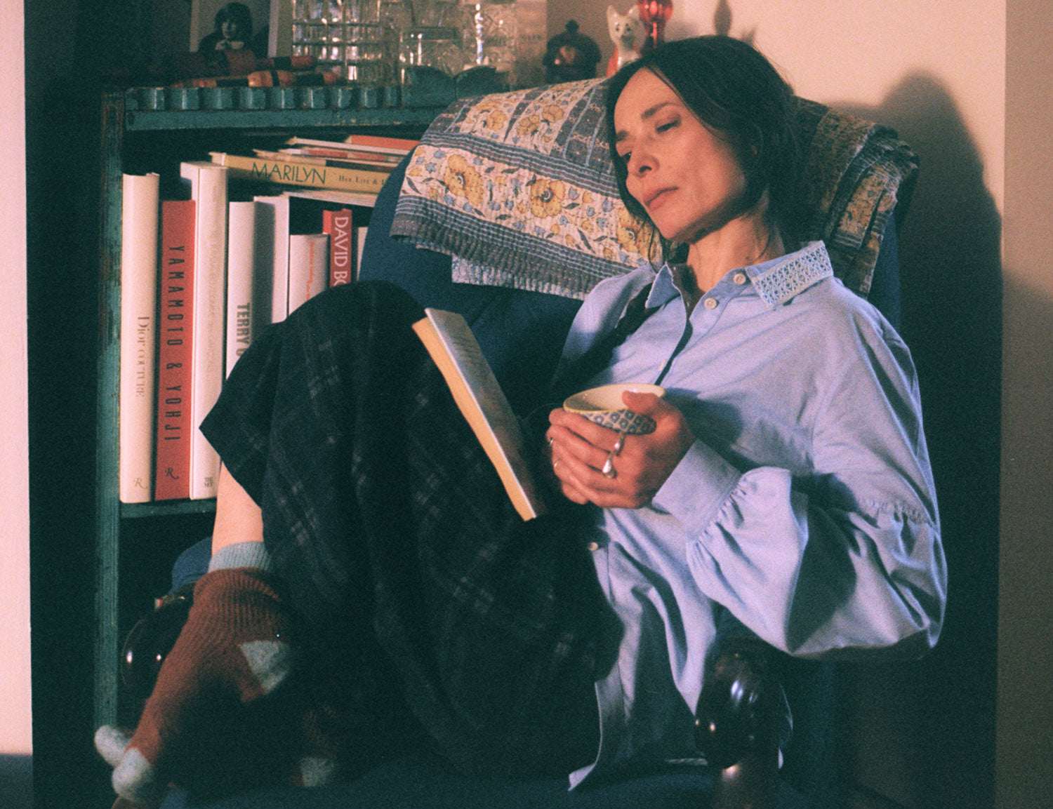 Edi pale blue shirt styled with Amelia navy check trousers in cosy armchair setting